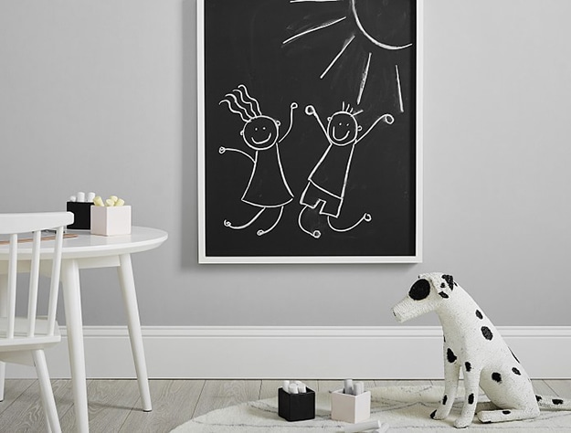 White table, chalkboard and stuffed dog. 
