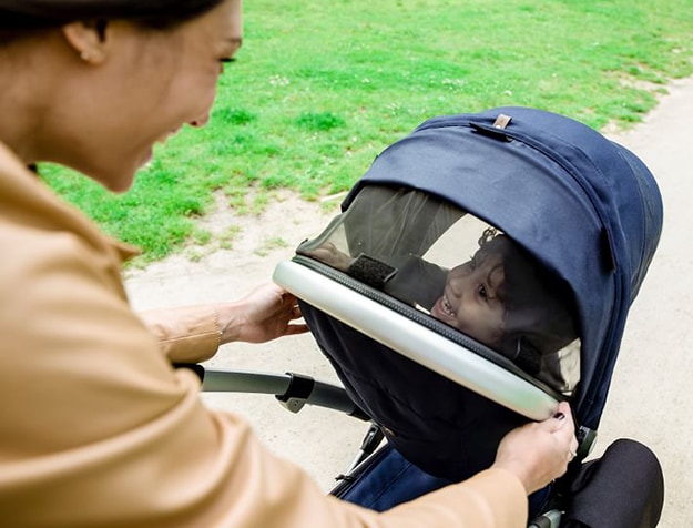 Happy mother and kid walking in stroller