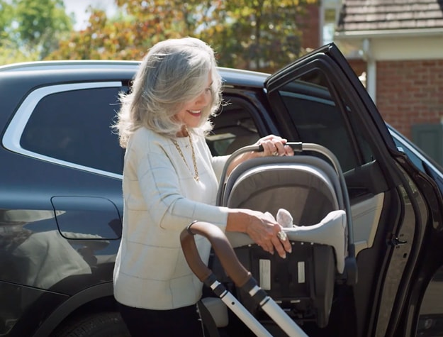 Grandma putting car seat in car