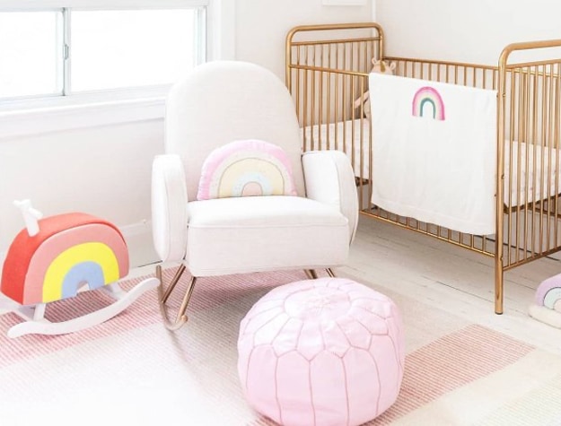 Nursery with rainbow pillows and blankets