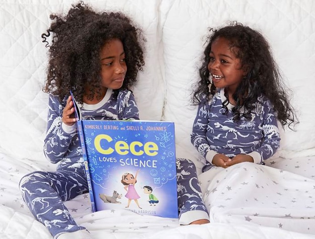 Little girls in bed reading book