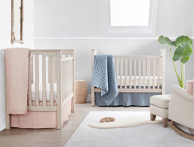 two white cribs in nursery