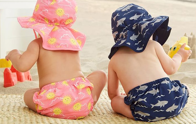 Two babies in matching hat and diaper sets