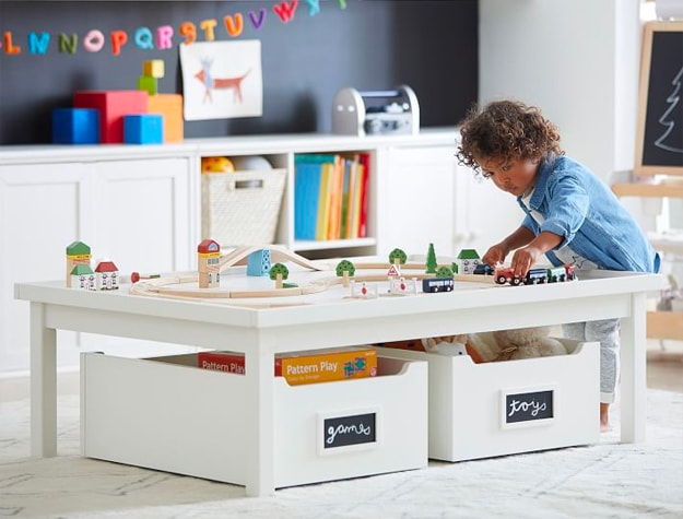 Child playing with toy car set on play table