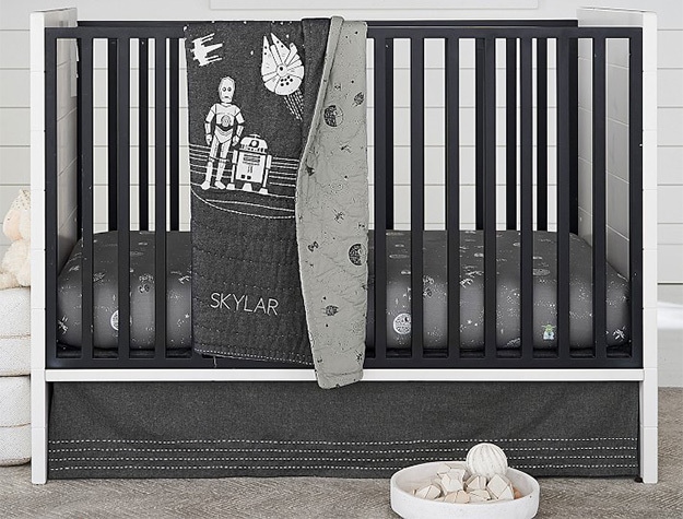 Black and white crib with star wars bedding.