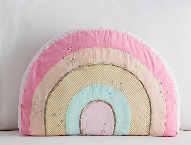 A plush pillow in the shape of a rainbow.