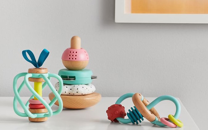 Three colorful wooden and cloth baby toys on table