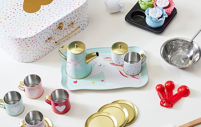 Unicorn rainbow toy tea set on table with baking utensils