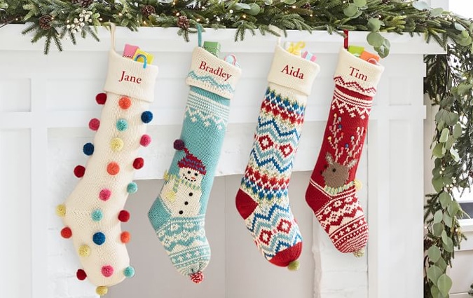 Four bright stuffed stockings hanging on the fireplace