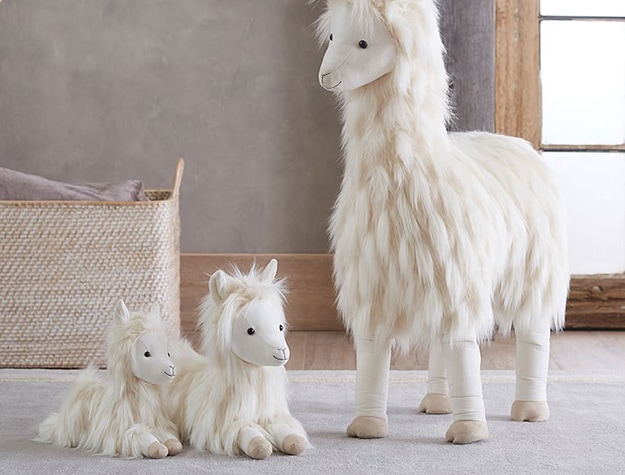 Three white plush llama toys standing and laying down
