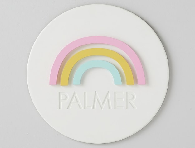 white wall plaque with pastel rainbow and the name “Palmer”