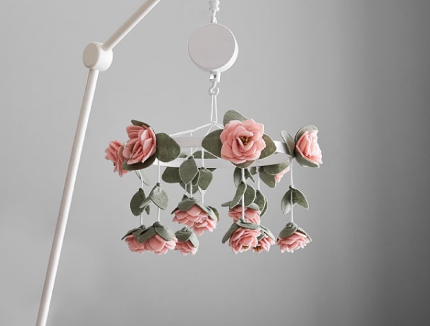 suspended crib mobile decorated with felted pink flowers