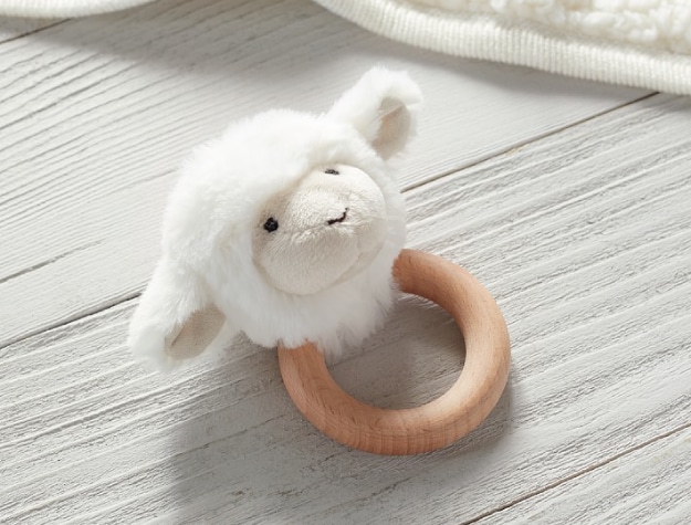 fuzzy lamb head rattle attached to a thick wooden ring
