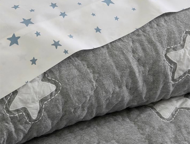 Close up of Shining Star Glow-in-the-Dark Quilt & Shams on bed.