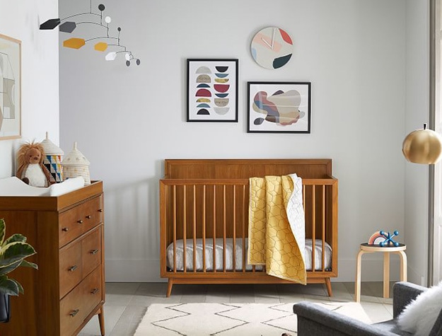 West elm x pbk did century convertible crib with wall art, hanging asymmetry shapes in nursery.