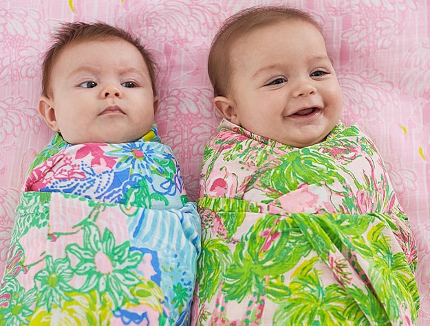 Two babies wrapped in bright Lilly Pulitzer floral swaddles for sleep sack vs. swaddle comparison.