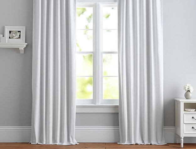 White Evelyn Linen Clackout Curtain Panel above window with gray walls