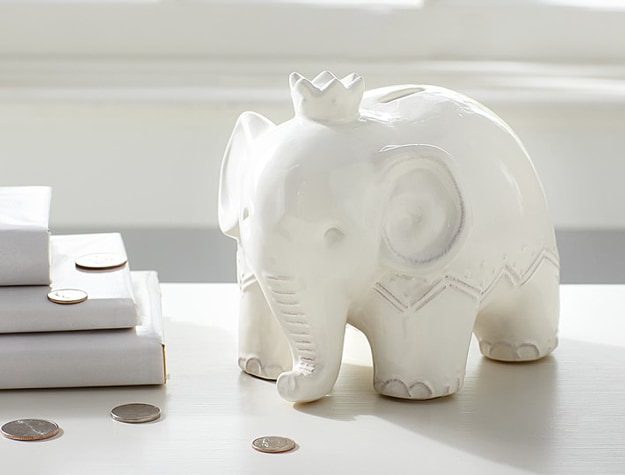 Elephant Coin Bank for Kids with change on a table top.