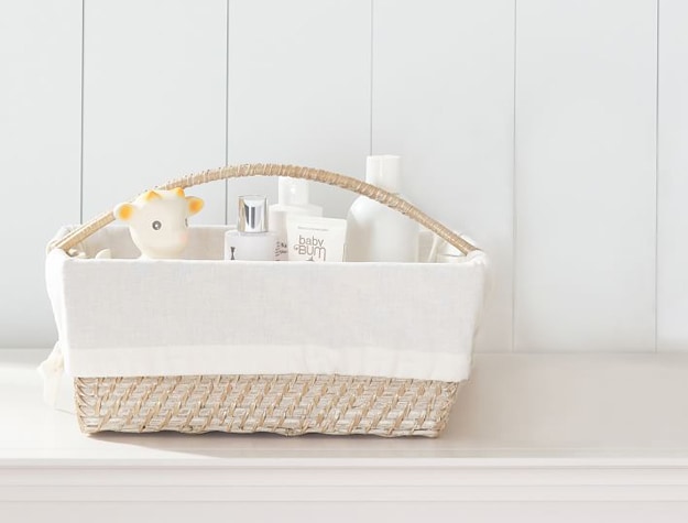 Quinn Changing Nursery Storage Liner in a basket with baby skin care items.