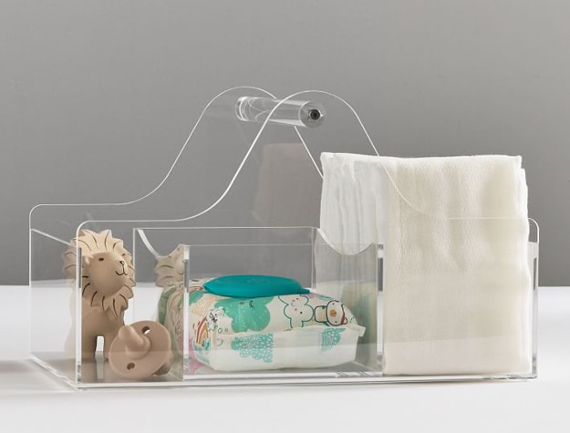 Acrylic storage basket with disposable wipes, diapers and toys.