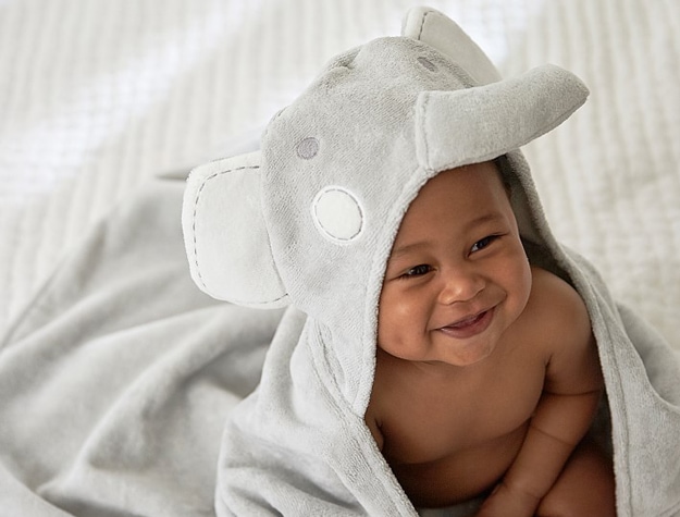 Baby wearing elephant hooded towel at daycare.