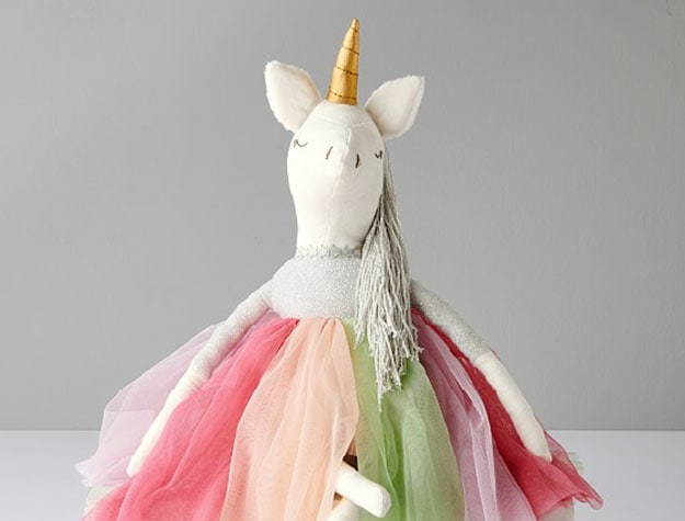 A unicorn designer doll wearing a colorful skirt.
