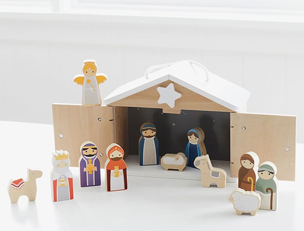 A wooden nativity set on a white surface.