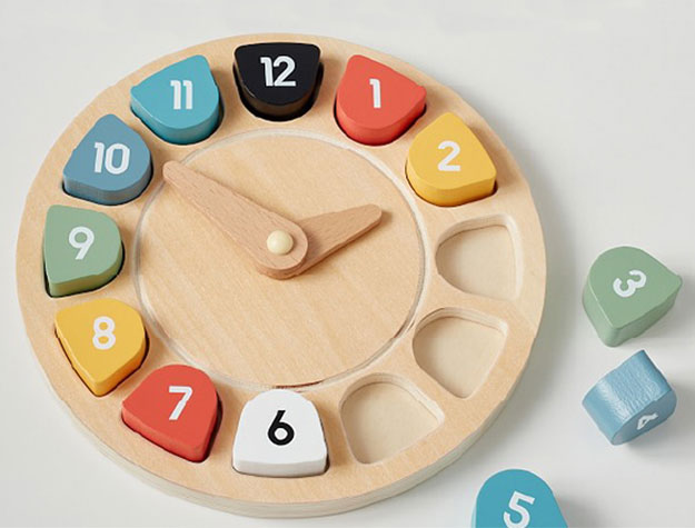 A colorful wooden clock puzzle with scattered pieces ready to be placed.