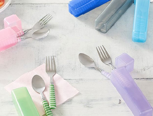 Colorful utensils and carrying cases in assorted colors placed on a table.