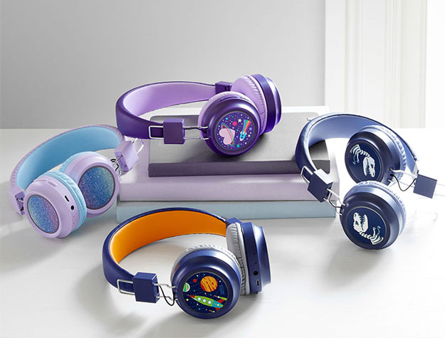 Four pairs of themed headphones sitting on stacked books.