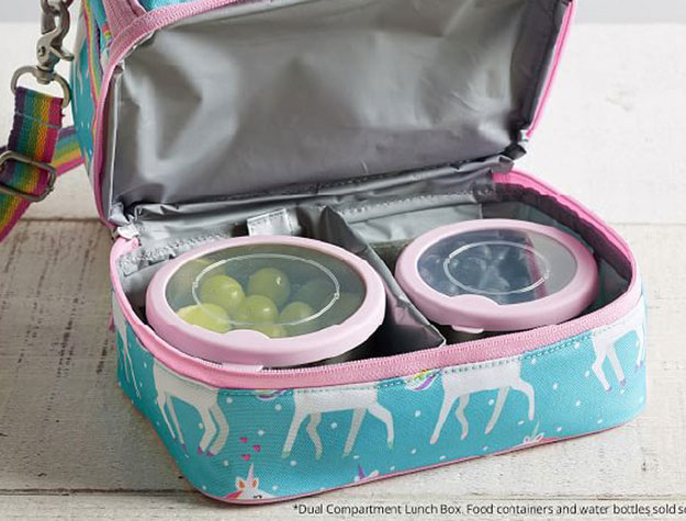 A colorful children’s lunchbox open to reveal containers of food inside.