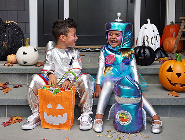 Two young children playing in astronaut costumes.