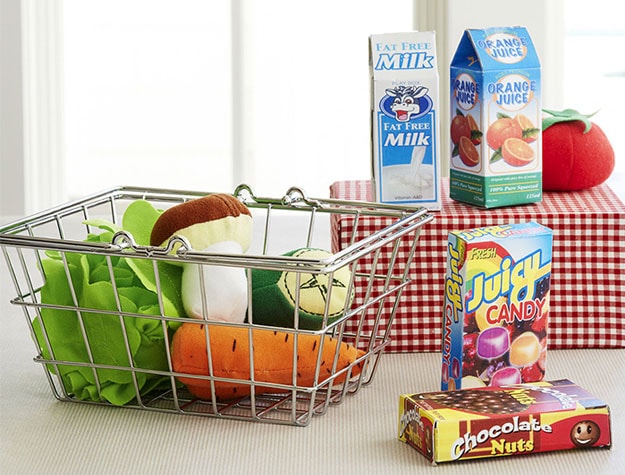 Play foods in a small shopping basket and on top of a small checkered table.
