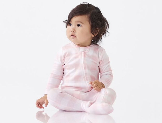 Baby wearing pink striped onesie with white background.