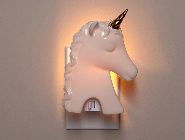 Unicorn night light plugged into wall outlet.