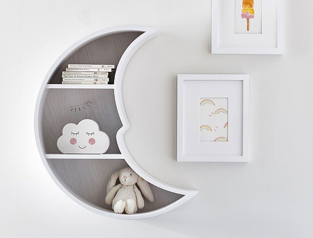 Moon-shaped wall shelf with books and toys