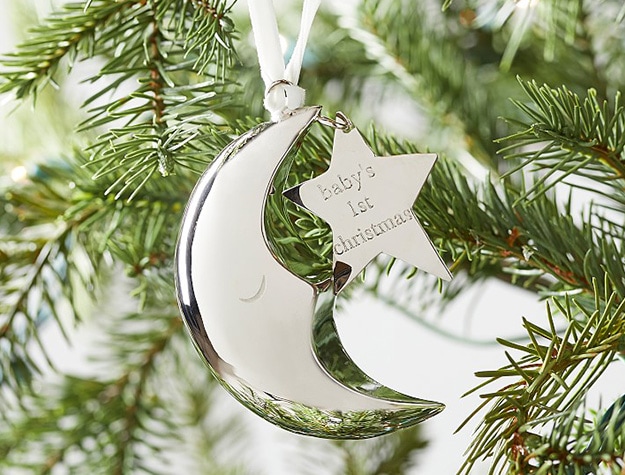 Gold crescent moon Christmas ornament with star-shaped pendant engraved with phrase “baby’s first christmas.”
