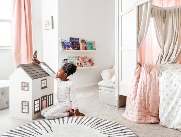 Girl playing with her dollhouse with wall shelves