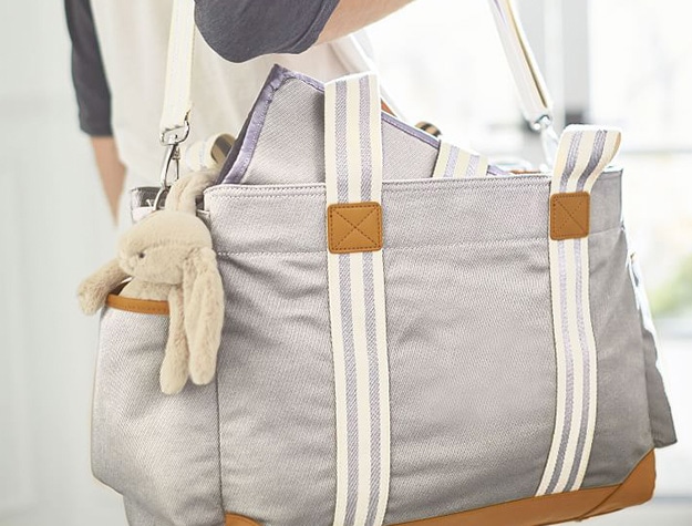 Stylish travel diaper bag with toy bunny in the side pocket.