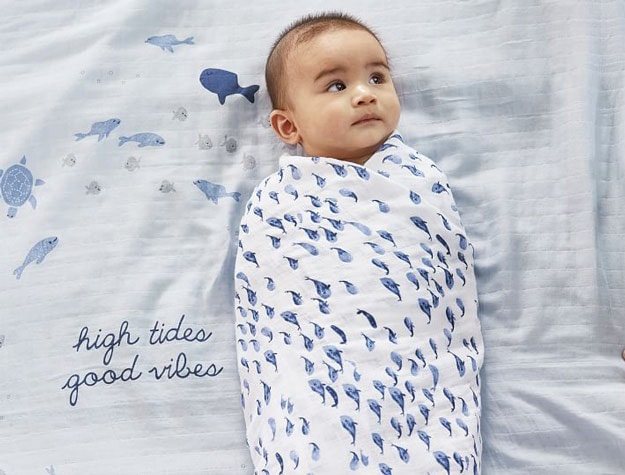 Baby in blue whale themed swaddle