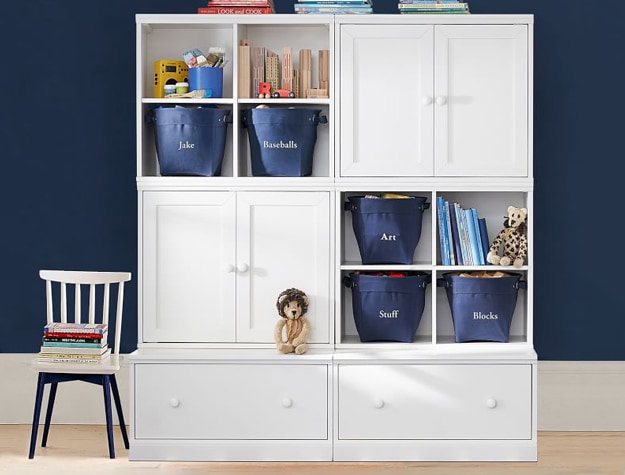 White storage shelves with labeled navy storage bins.