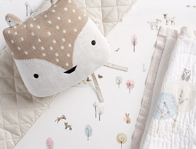 Dakota Woodland Baby Bedding on a crib with a fox pillow.