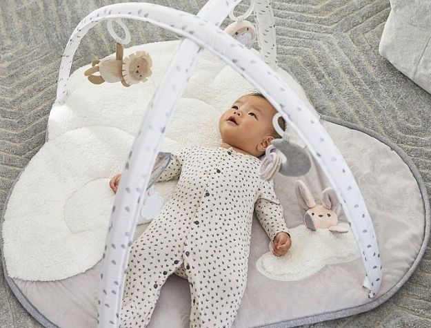 baby playing in activity gym