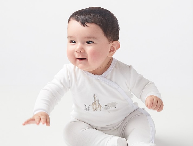 Baby wearing white pajamas with animals