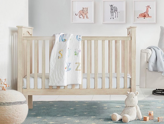 Wooden crib with alphabet blanket hanging on it. Wooden crib with alphabet blanket hanging on it.