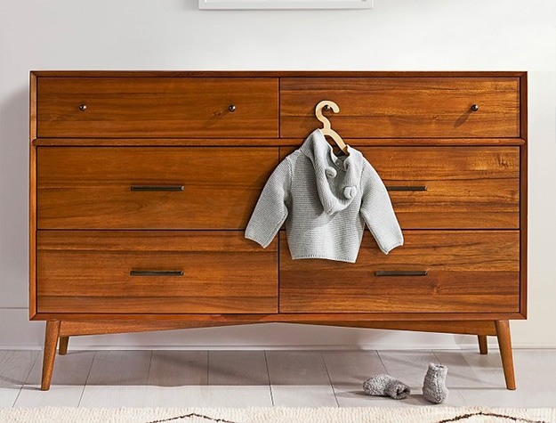 mid century modern dresser with a gray children’s jacket