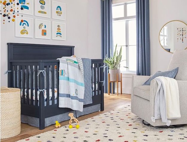 Nursery with blue crib and natural wicker hamper basket