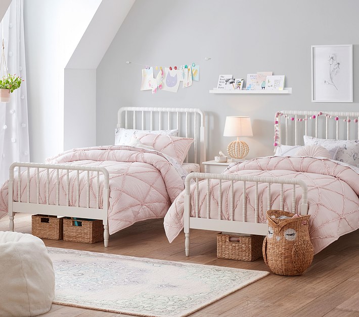 Two white wooden bed frames in a shared girls' room