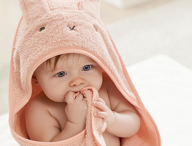 baby in coral hooded towel with bunny ears