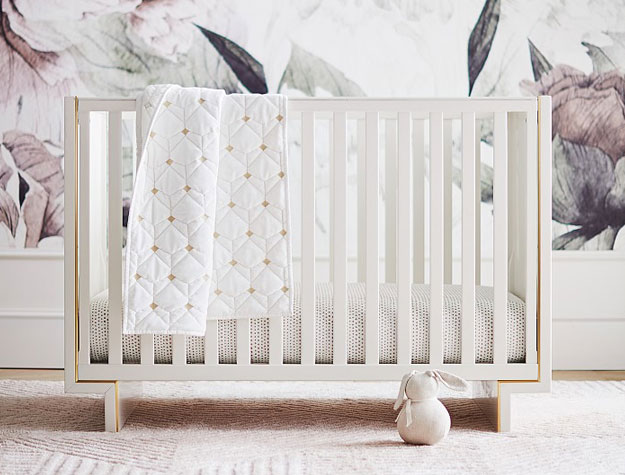 white art deco crib with gold trim